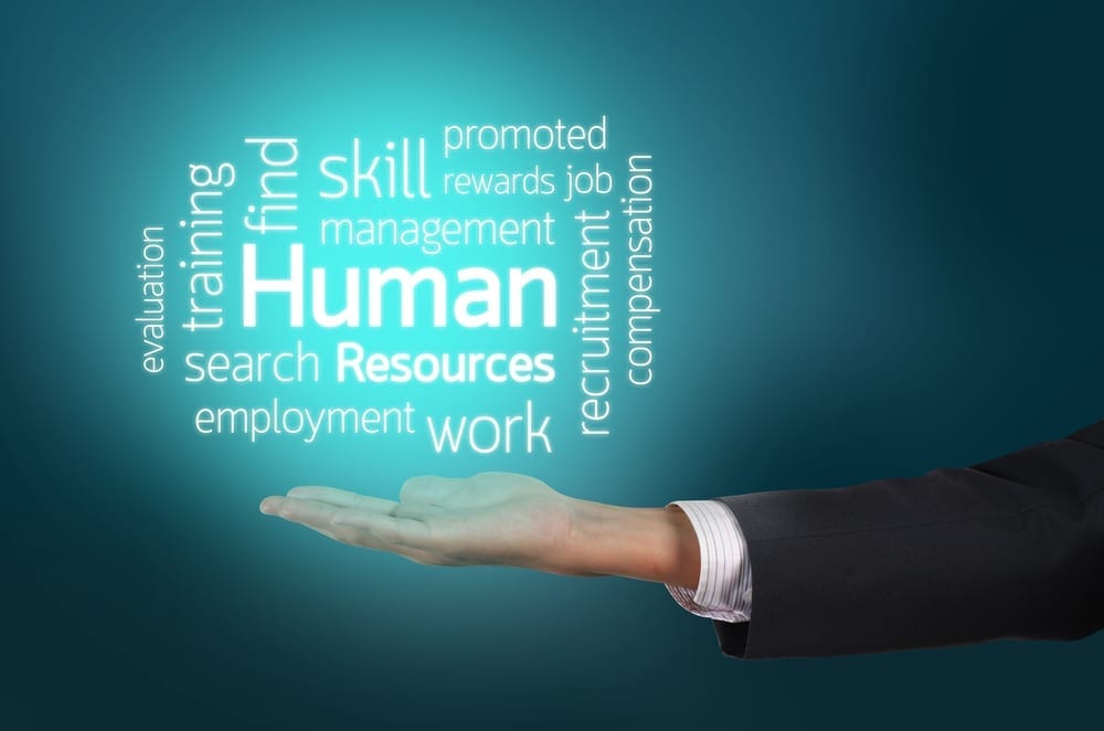 A word cloud containing HR terms - positioned above an open hand