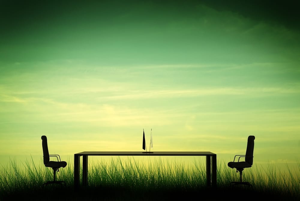 A long business meeting table with an empty chair at each end