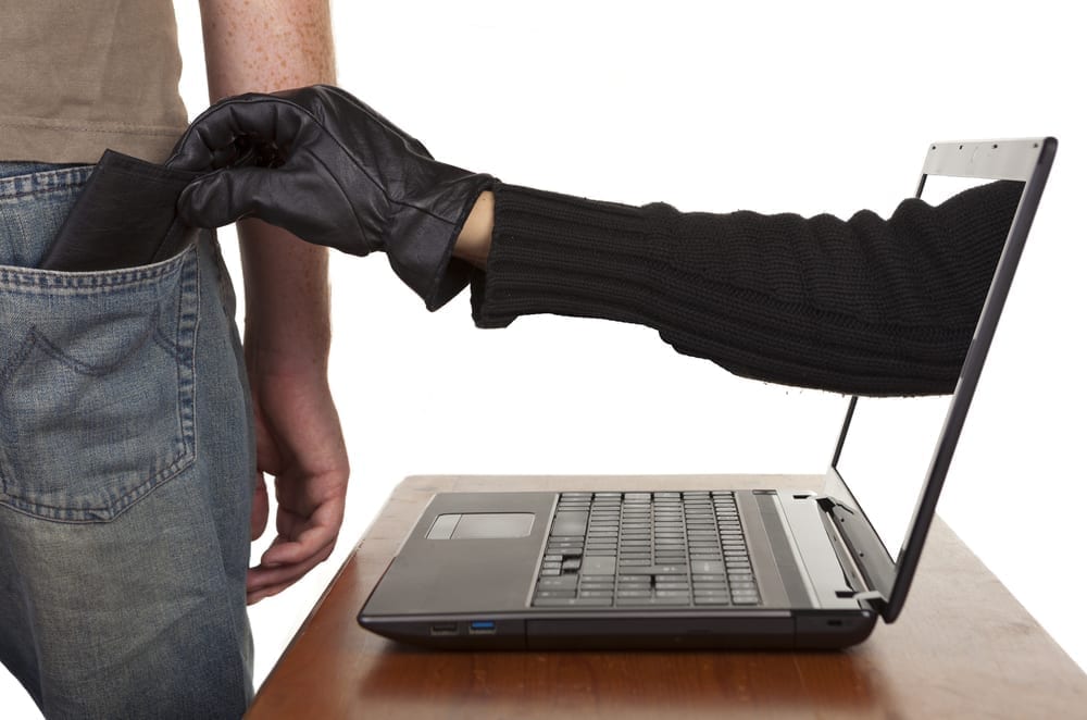 An arm reaching from a laptop screen stealing another persons wallet