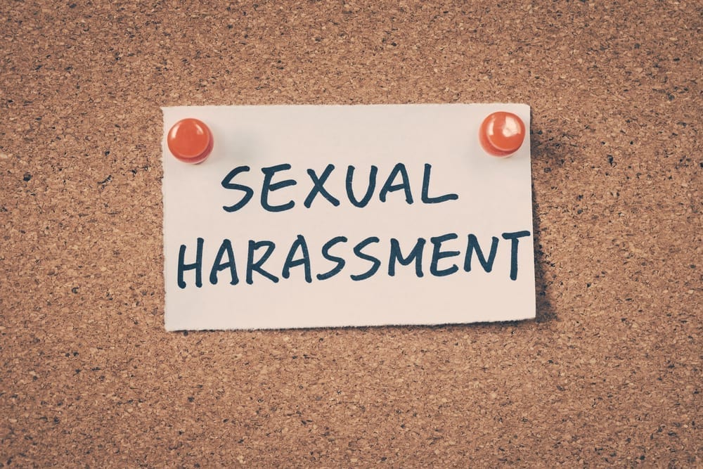 A piece of paper on a cork board reading "Sexual Harassment"