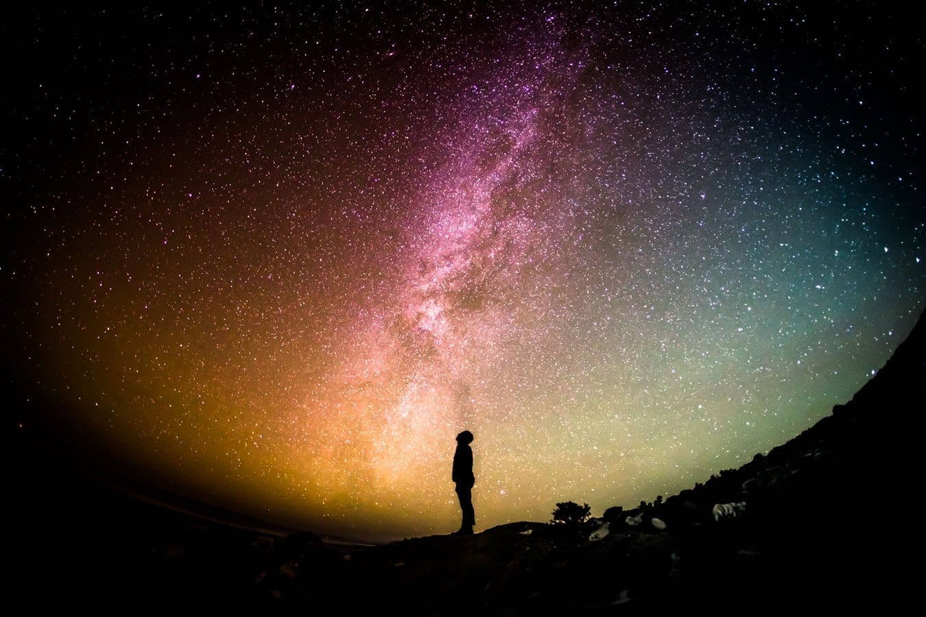 A silhouette of a person looking at the night sky