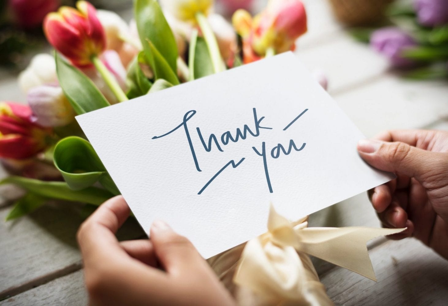 A bunch of flowers with a note reading "Thank you"