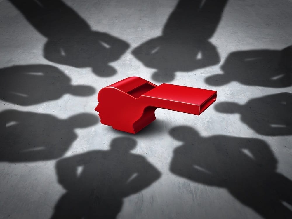 A red referee whistle in the middle of a circle of shadows depicting a group of people
