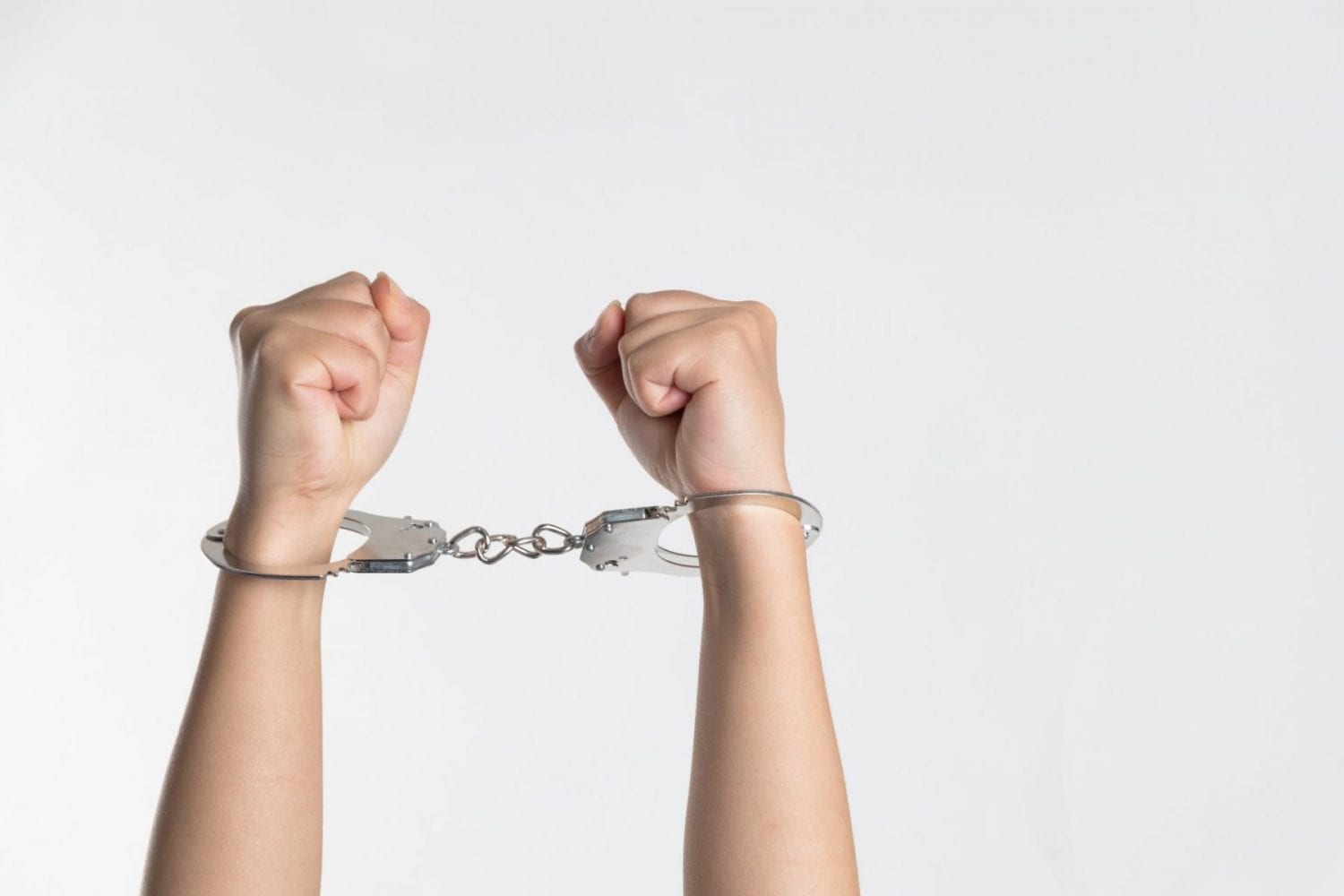 A person hands bound with handcuffs