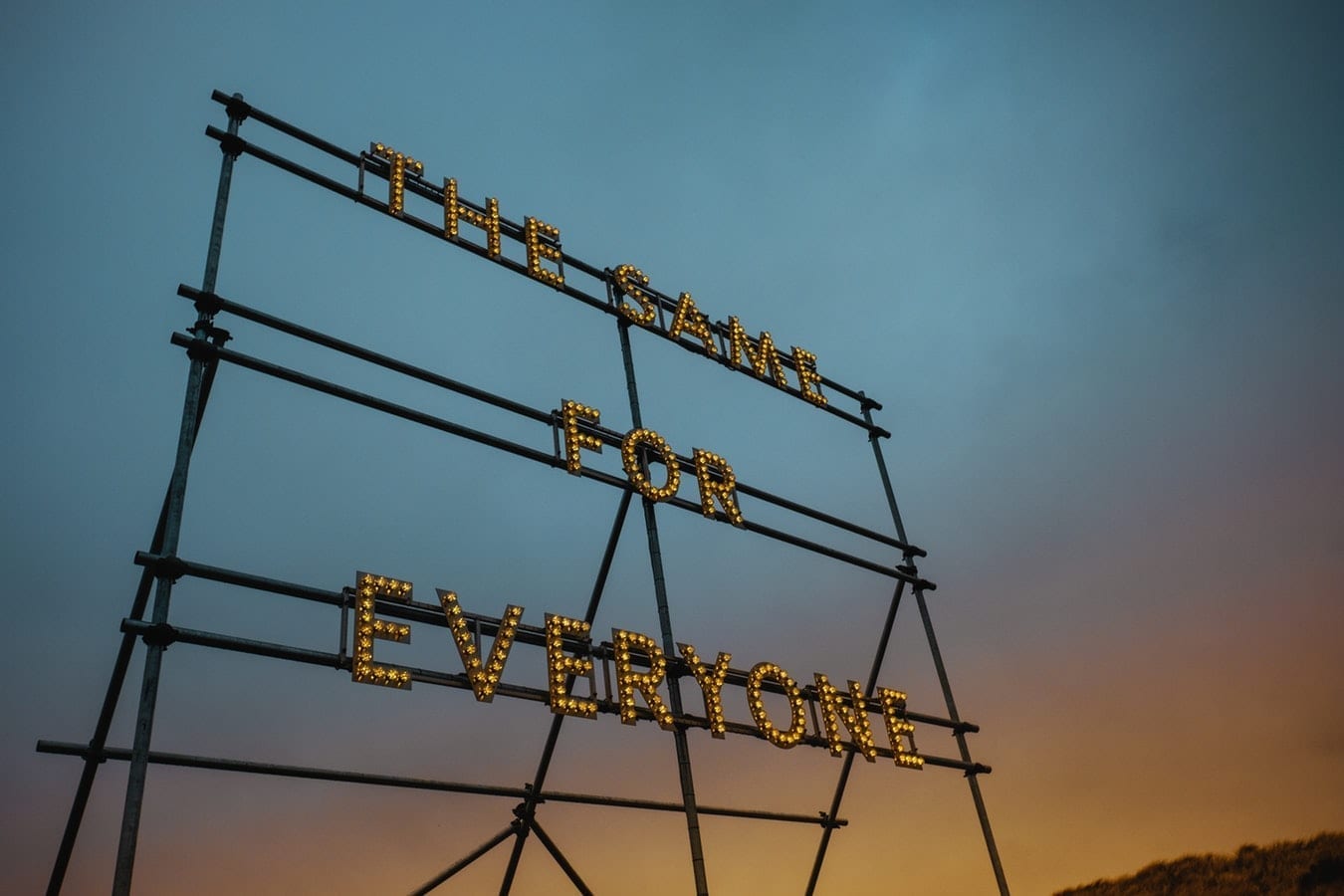 A large roadside sign with the words "The Same For Everyone" in lights