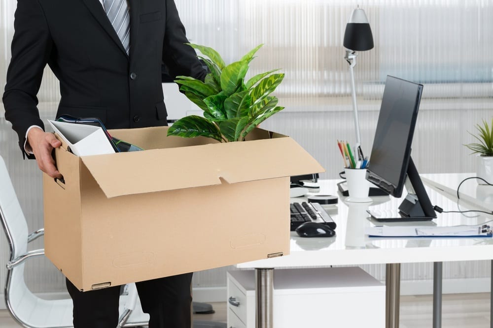 A person packing up their belongings in a cardboard box in an office environment