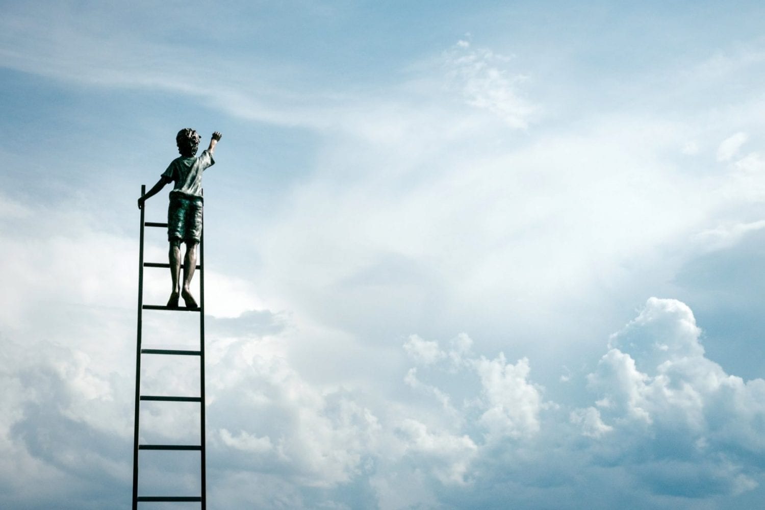 A child climbing a ladder reaching for the sky