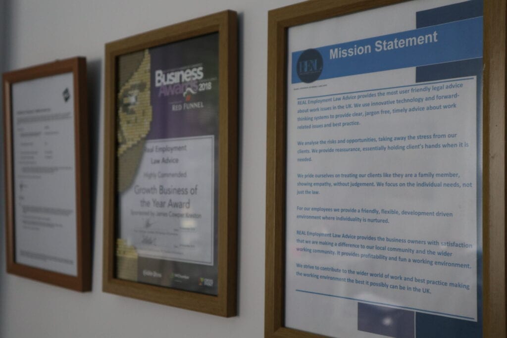 A collection of framed documents on an office wall