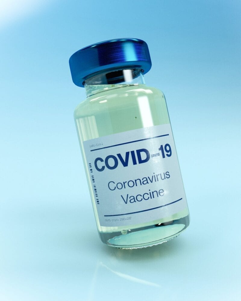Small glass vial with covid-19 written on to indicate a vaccine