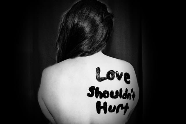 Person with the words "Love shouldn't hurt" written on their back