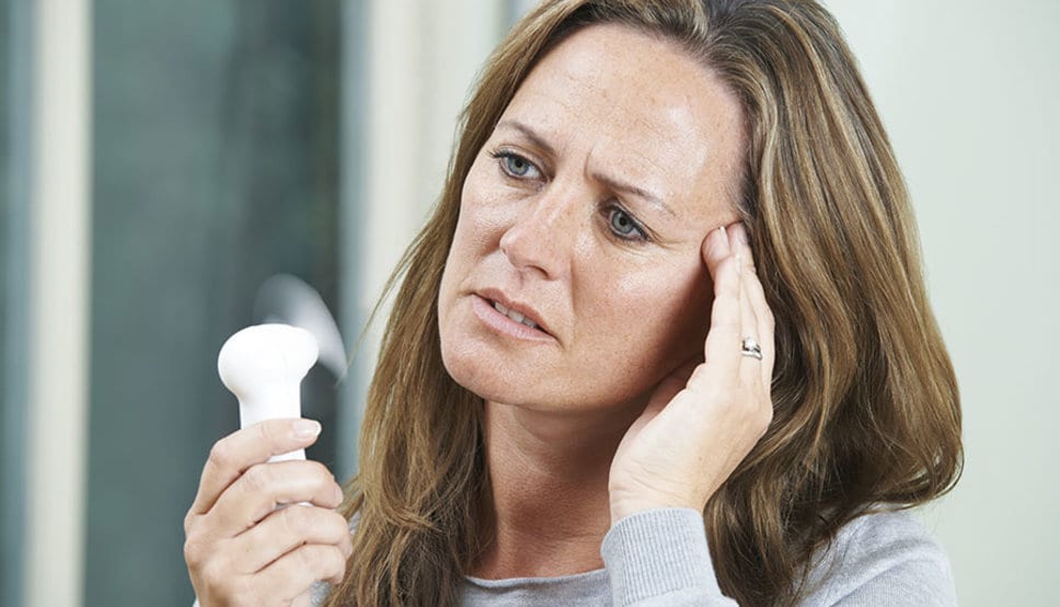 Mature Woman Experiencing Hot Flush From Menopause