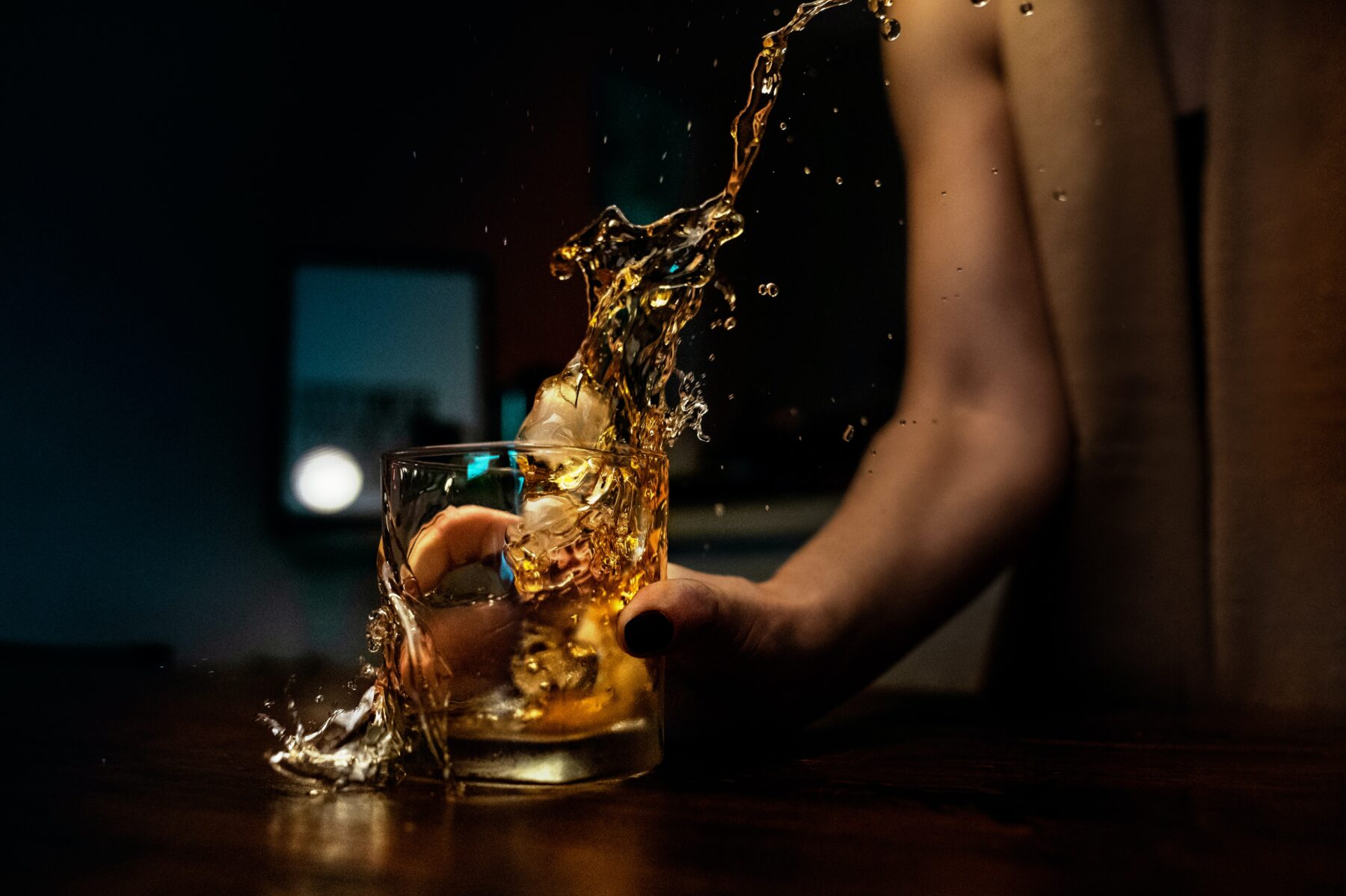 A glass of liquid being slammed down, with its contents flying out everywhere