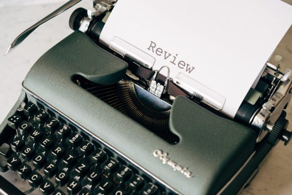 A typewriter, with a document titled "Review"